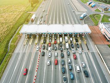 Maut und Vignette in Europa 2026: Alle Reiseländer im Überblick - Mautstation An overhead view of a busy toll road with many cars queuing up to pay the highway toll Blick von oben auf eine stark befahrene Mautstraße mit vielen Autos, die Schlange stehen, um die Autobahngebühr zu bezahlen Maut, Mautstation