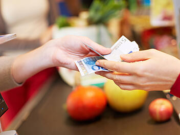 Wer Preise vergleicht und Angebote nutzt, kann beim Wocheneinkauf viel sparen. Bargeld, Kasse, Supermarkt, Einkauf